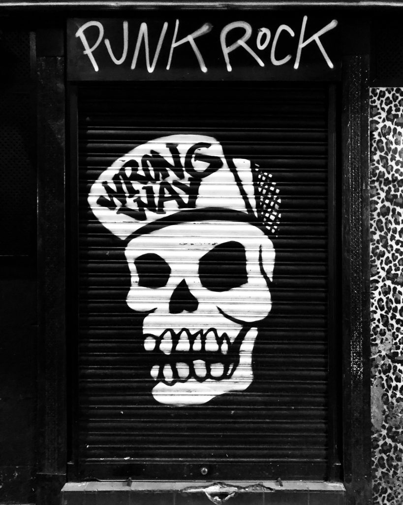 Funky skull graffiti on locked roll down black door